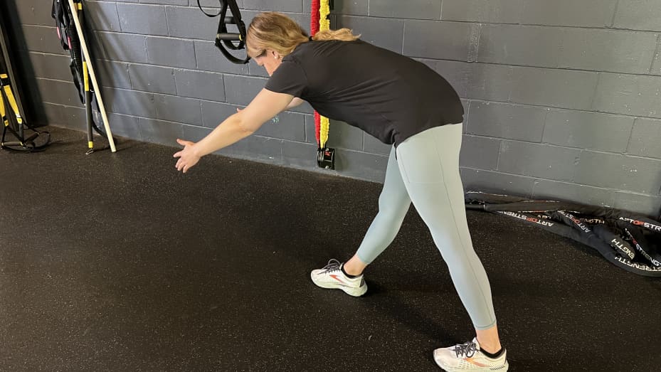 Part 1: Place one foot about 18 inches in front of the other, then lean forward at the hips and reach your arms out in front of you.